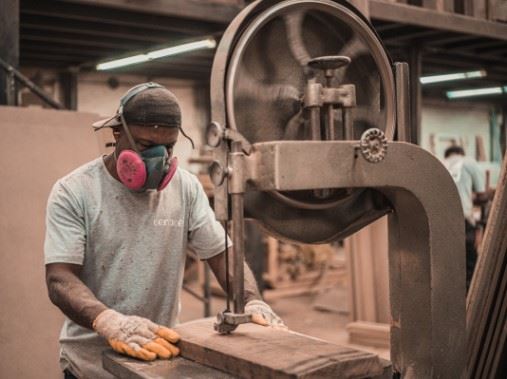 wood-worker using table saw in a shop to symbolize workers compensation in Illinois